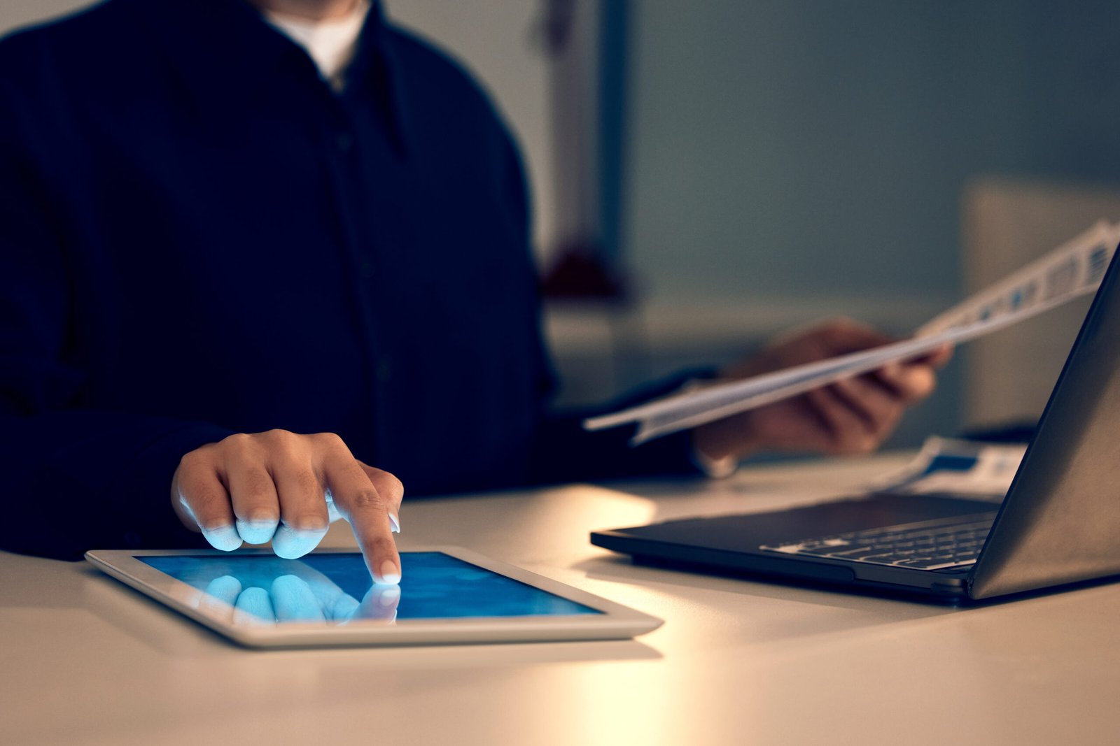 Hand, tablet and laptop in night at office for research, analysis and web design at desk for tech i.